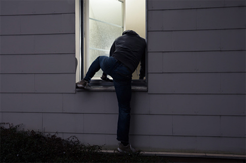 Thief crawling through window